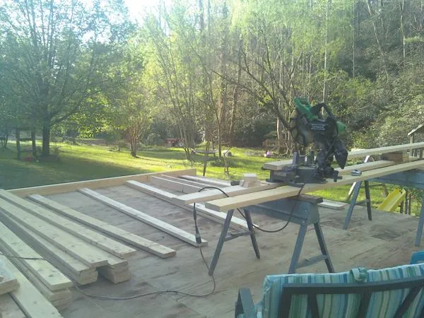 Miter saw and framing lumber on a deck under construction in Winfield